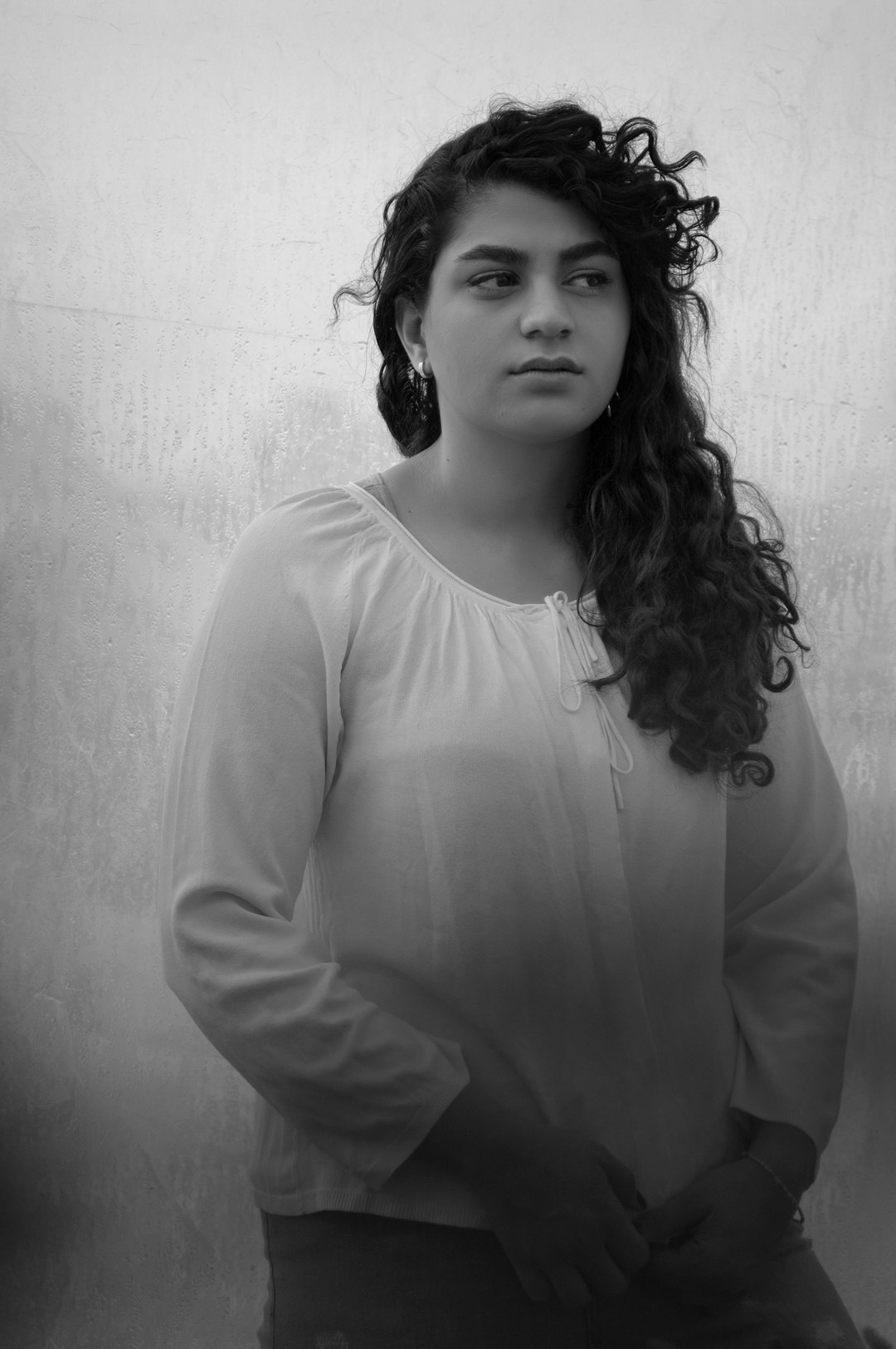 Studio portrait of a young Latina woman with wavy hair smiling