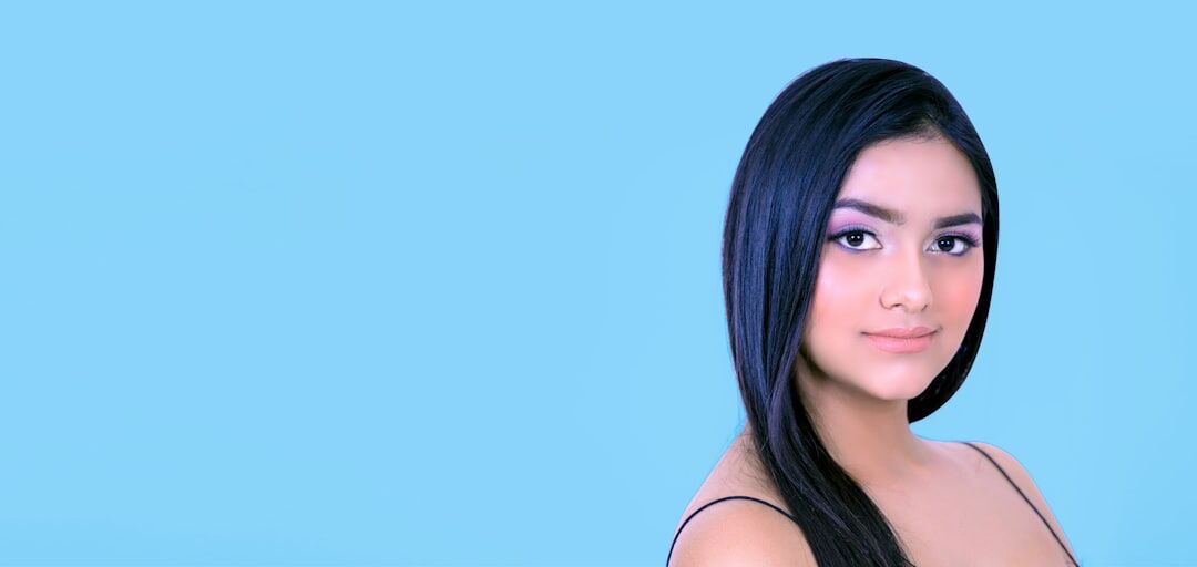 Studio portrait of a young Latina woman with straight hair smiling