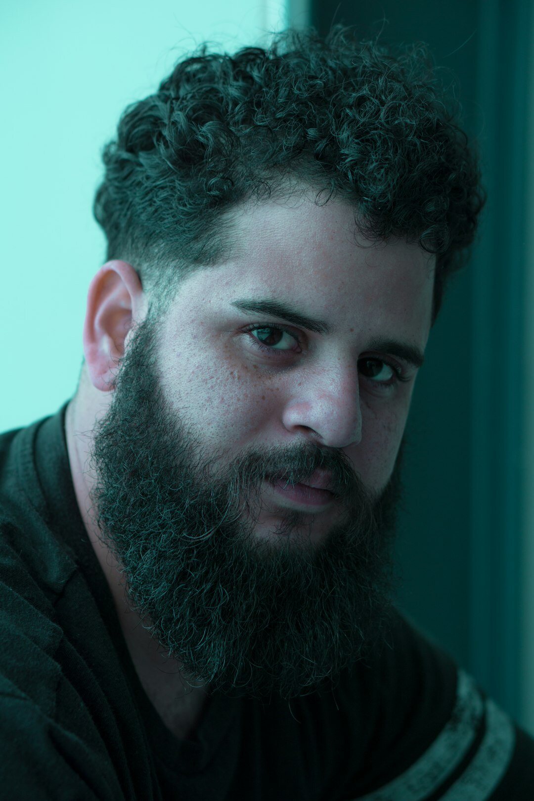 Studio portrait of a young Latino man with short beard